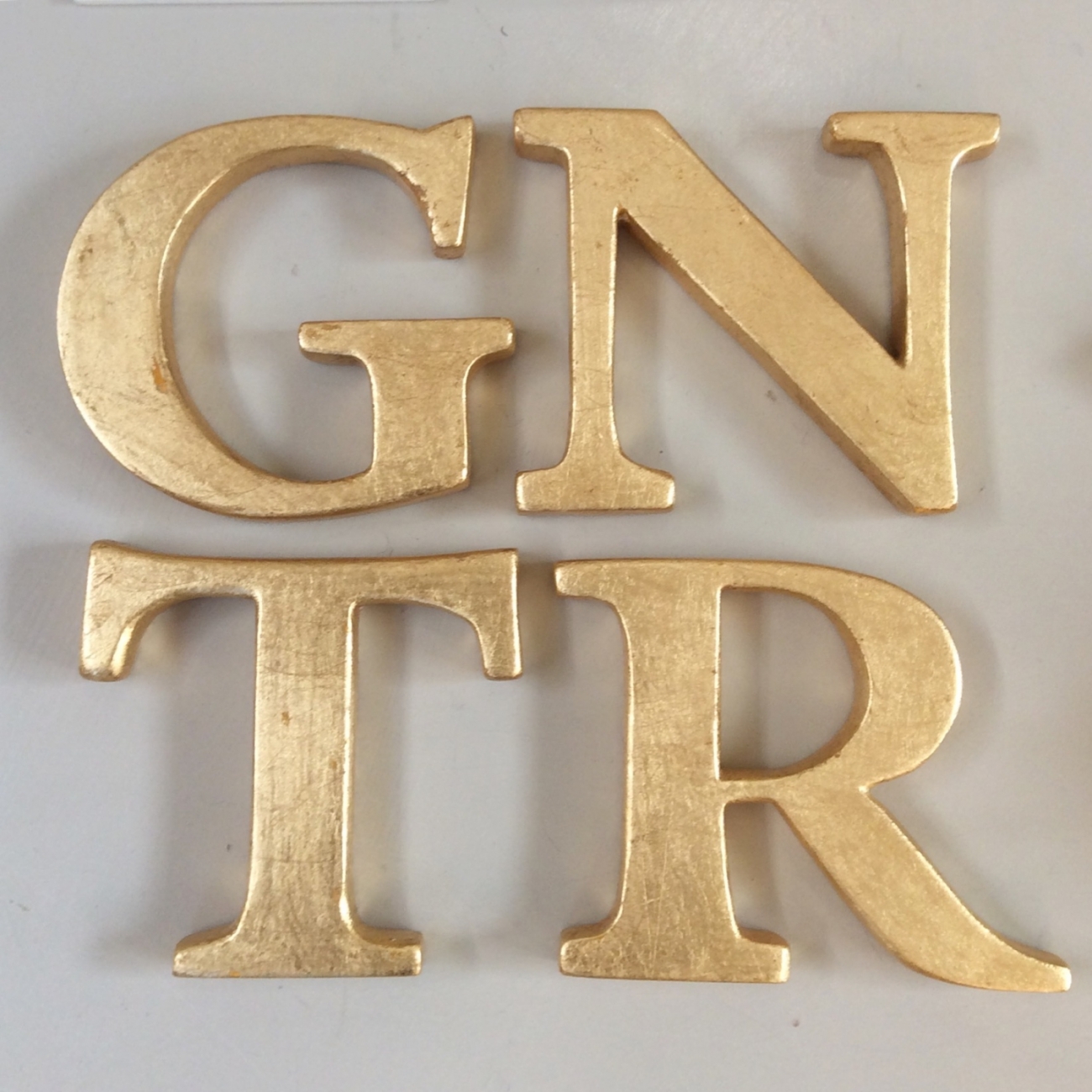 Gilded wooden letters Jane Harman storage and furniture restoration in Florence
